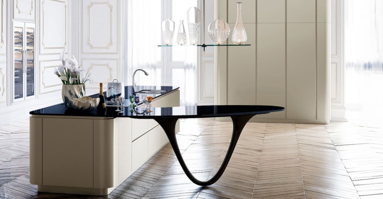 Îlot de cuisine de luxe de coloris noir et champagne micalisée avec une table en épis placé dans un salon Haussmannien