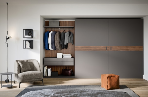 dressing moderne à portes coulissantes coplanaires plaqué bois et couleur gris mat encastré dans un mur