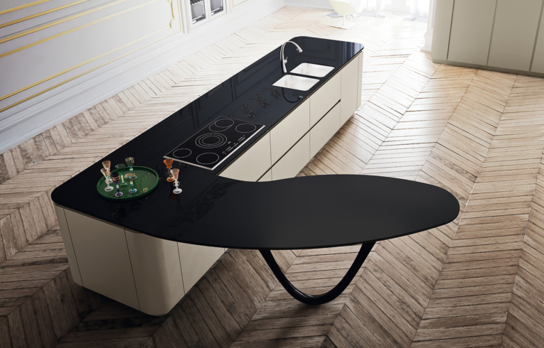 Ilot central d'une cuisine design avec table et plan de travail en verre noir pied en fibre de carbone noir