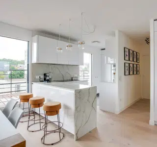 aménagement intérieur haut gamme d'une cuisine ouverte sur salon avec façades sans poignées
