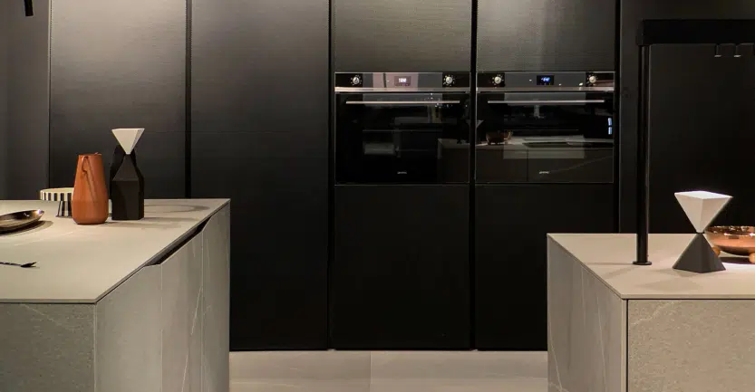 Cuisine ouverte avec colonnes de rangement noires et îlots en céramique gris