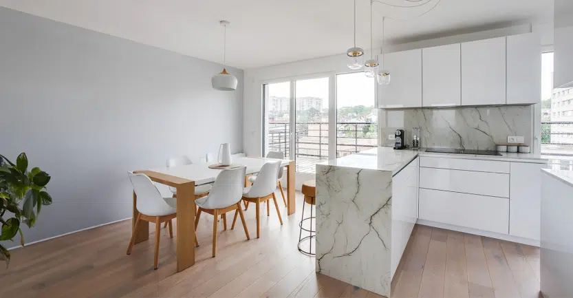 Cuisine ouverte sur séjour en meuble blanc laqué et table à manger